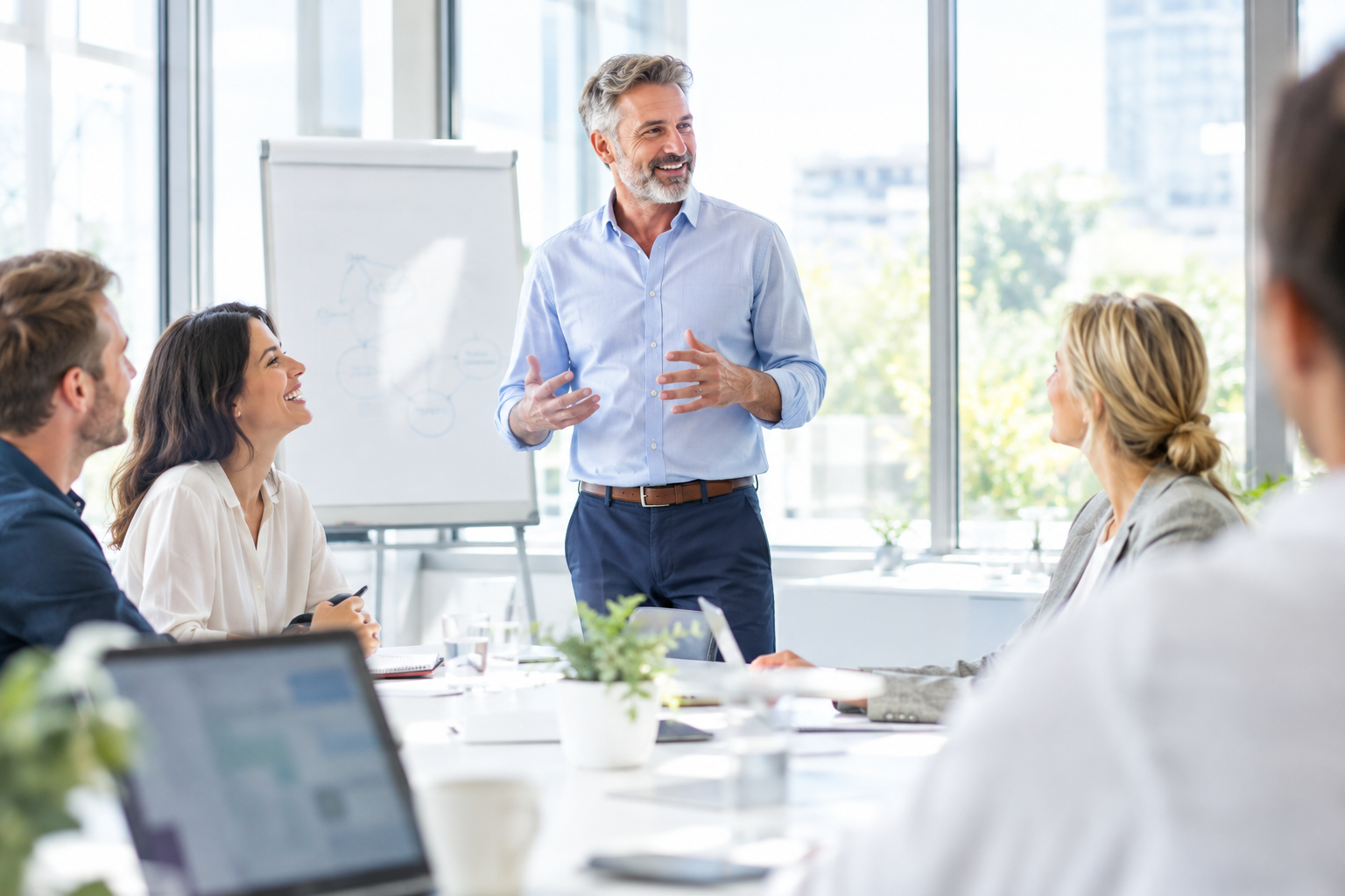 Formation en présentiel, formateur au paperboard devant un groupe de participants